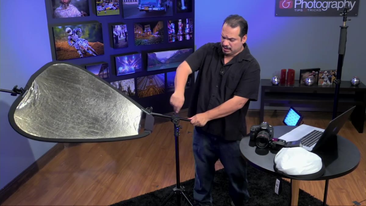 Top articulating knob being loosened to tilt and rotate the reflector head